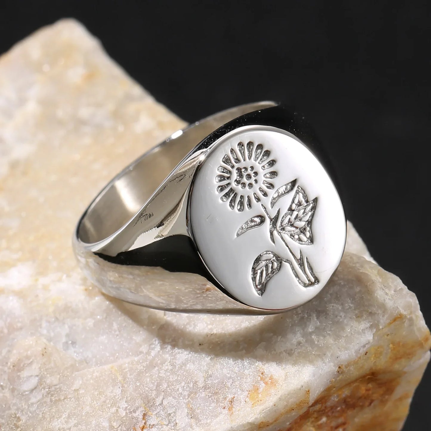 Silver signet ring with engraved floral design on white stone, minimalist jewelry style