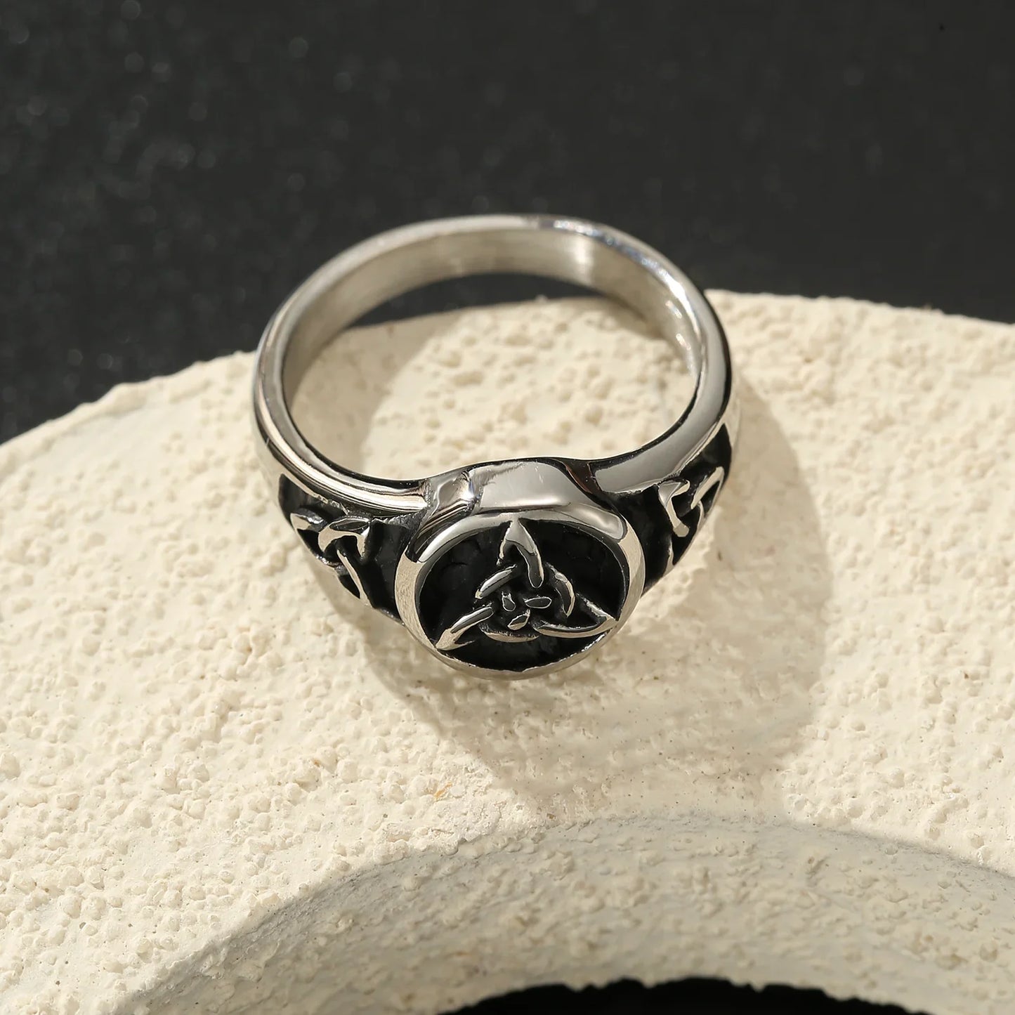 Silver Celtic knot ring with black enamel, modern minimalist jewelry on textured stone