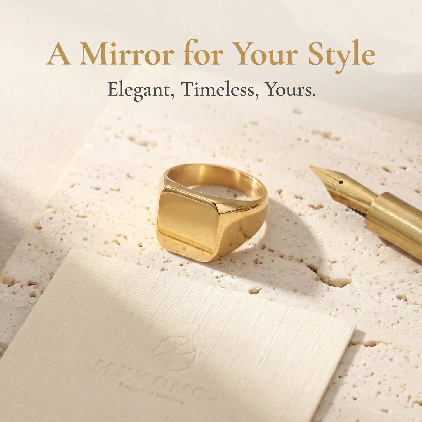 Minimalist gold signet ring with square face on textured stone beside a gold fountain pen