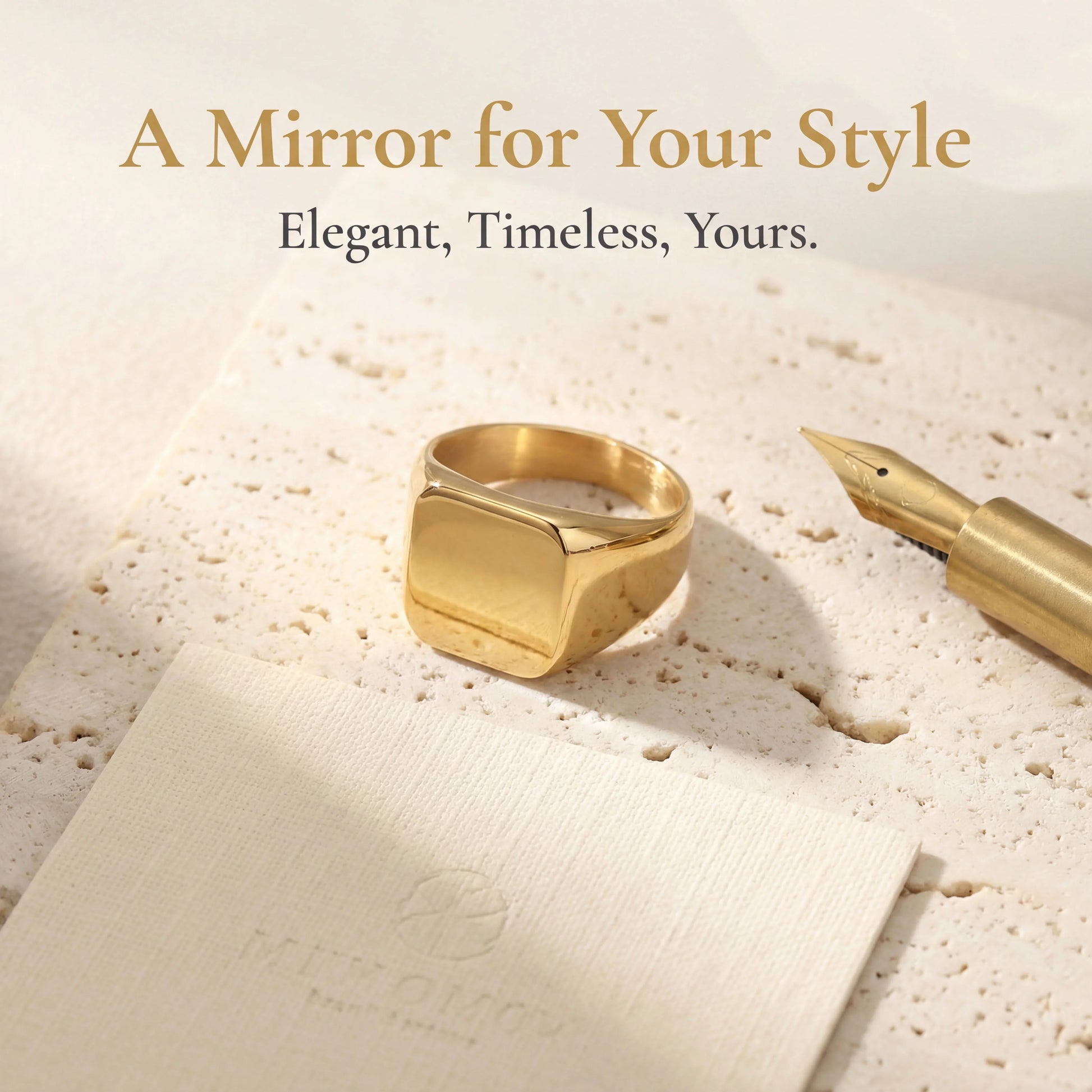 Minimalist gold signet ring with square face on textured stone beside a gold fountain pen