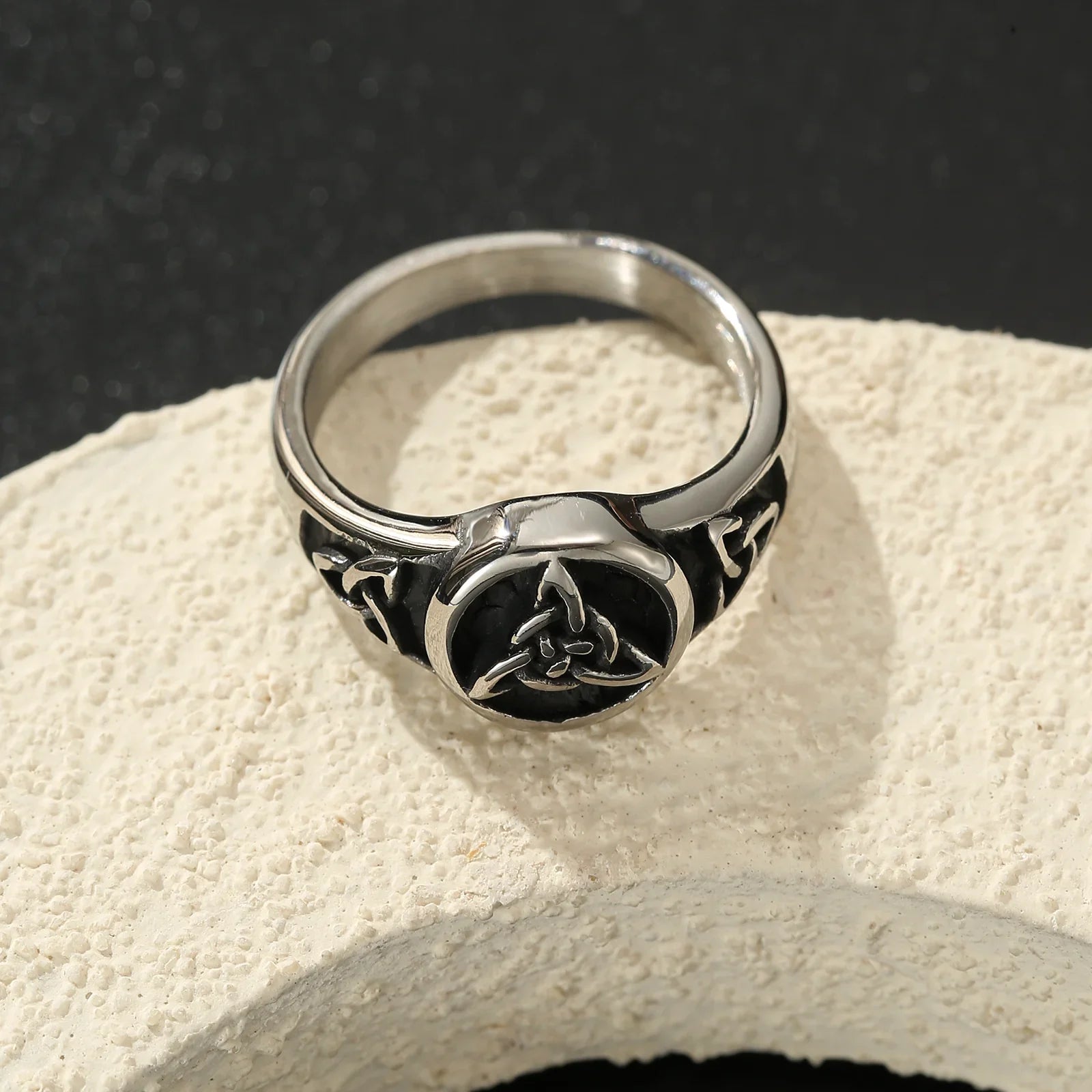 Silver Celtic knot ring with black enamel, modern minimalist jewelry on textured stone