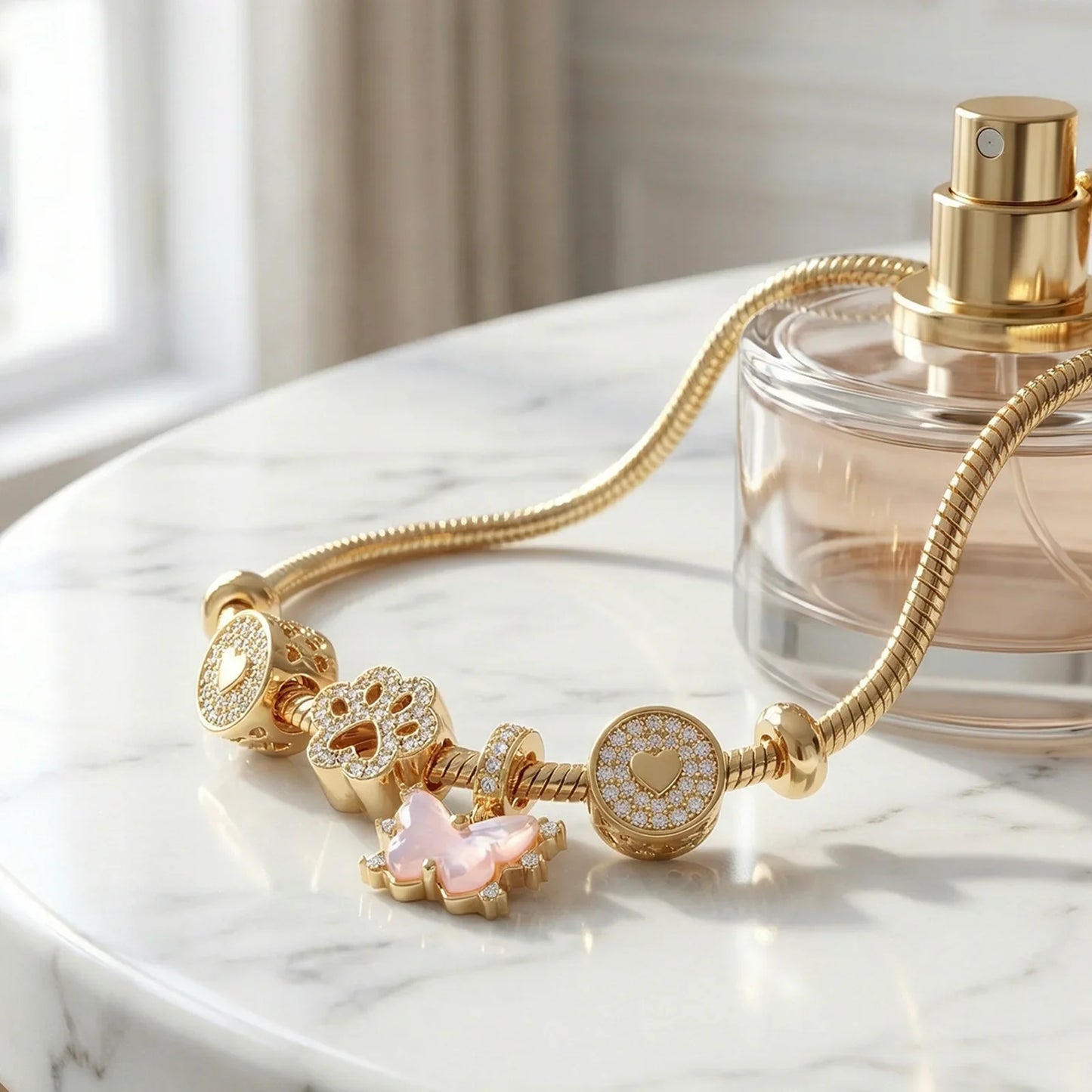 Gold charm bracelet with heart, flower, and butterfly pendants on marble surface